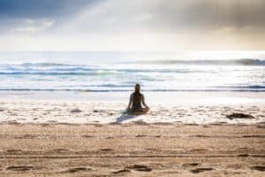 Yogareisen - Frau im Lotussitz am Manly Beach Australien