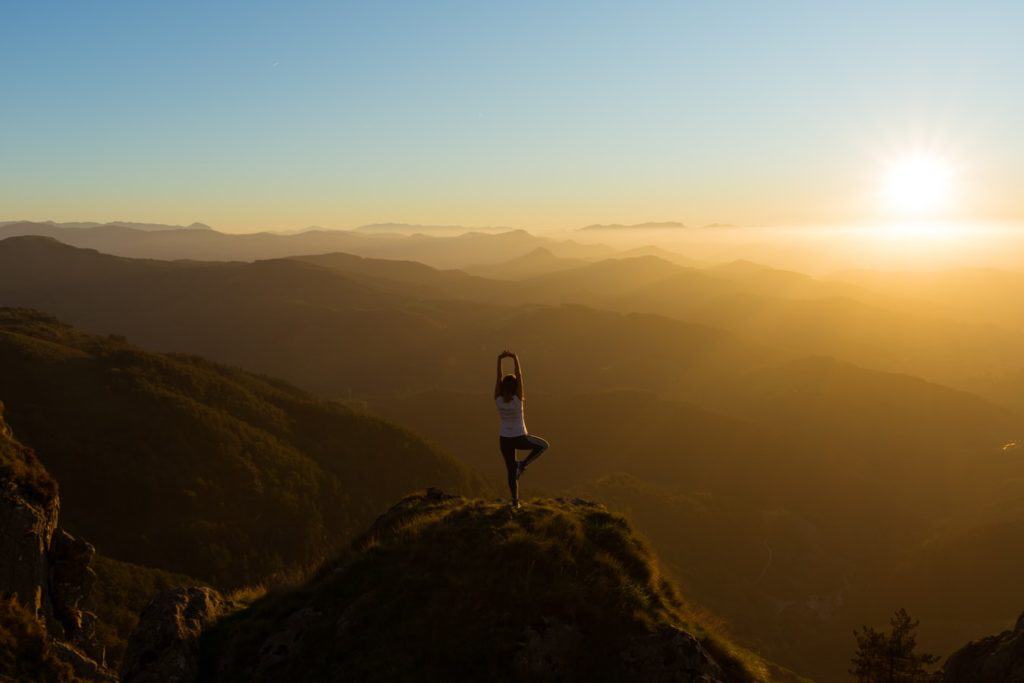 Yogareisen -  Frau in Yogastellung im Sonnenuntergang in Spanien