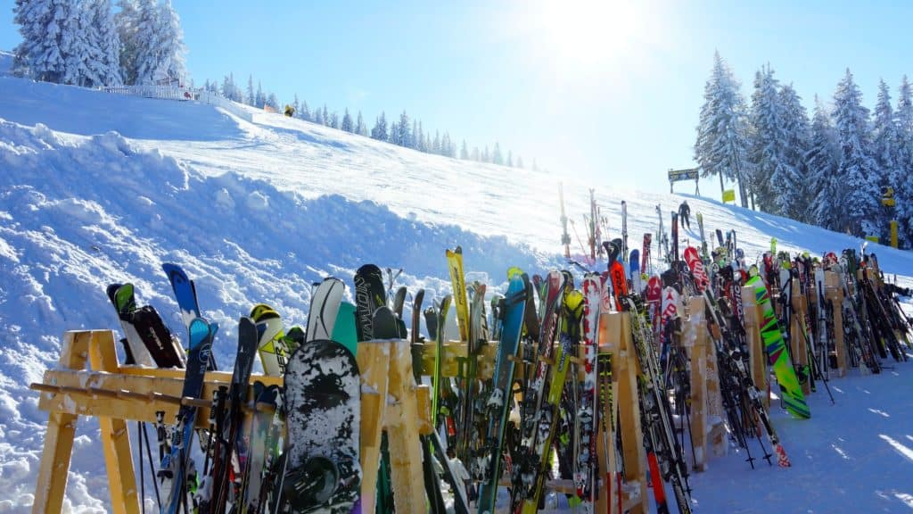 Skiständer im Schnee vor blauem Himmel im Gegenlicht